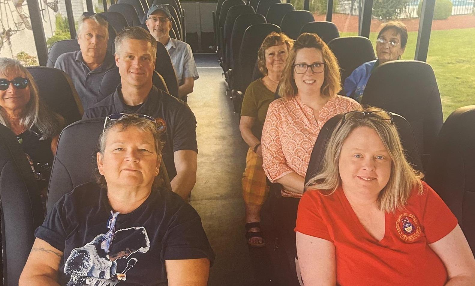Group of people in a bus smiling and talking